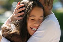 Mother hugging daughter